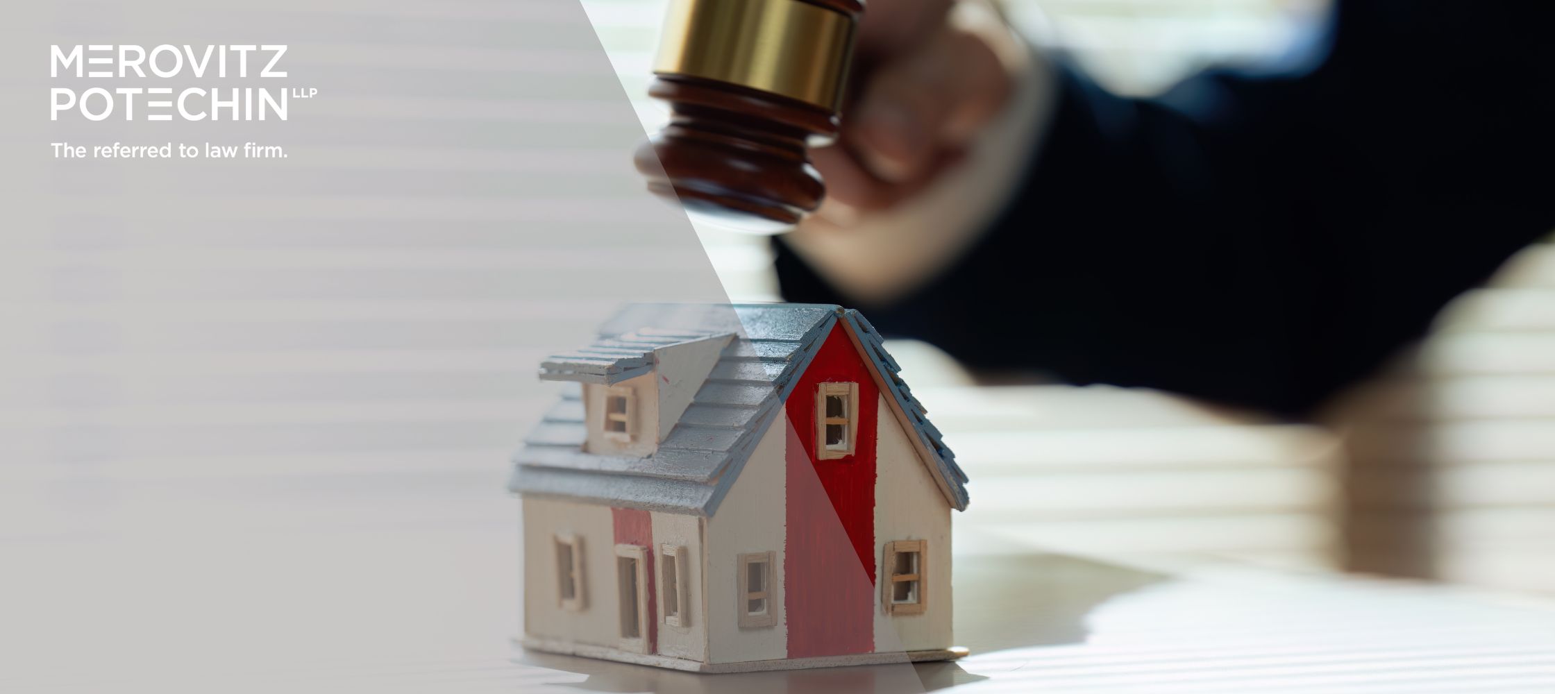 Wooden model house on a desk with a judge's gavel in motion, representing property disputes and legal proceedings. The image highlights the concept of Resulting Trusts in Estate Disputes. Merovitz Potechin LLP logo in the corner with the tagline 'The referred to law firm.